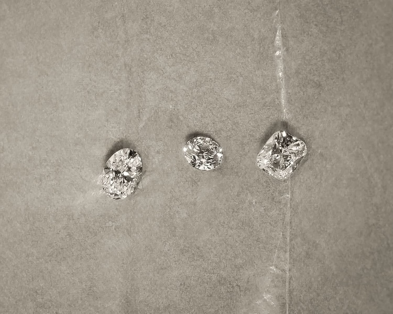 Three loose lab-grown diamonds resting on tissue paper